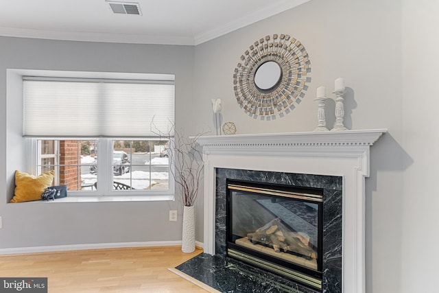 interior details featuring wood-type flooring, ornamental molding, and a fireplace