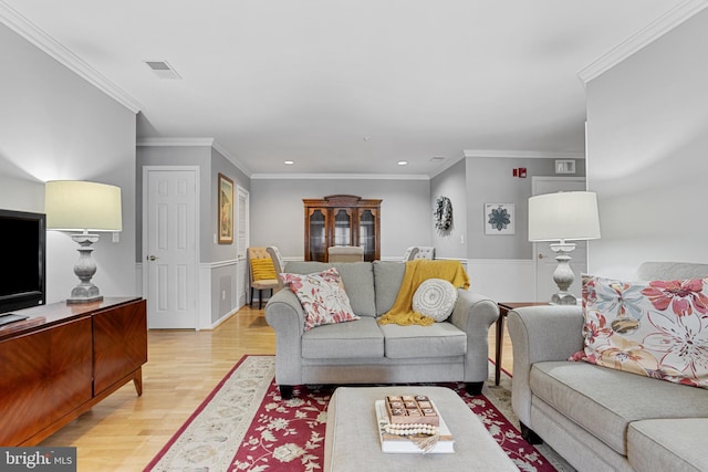 living room with light hardwood / wood-style flooring and ornamental molding