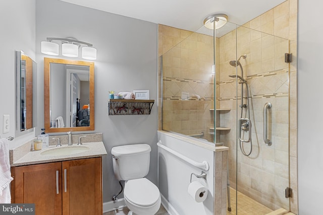 bathroom featuring toilet, a shower with door, and vanity