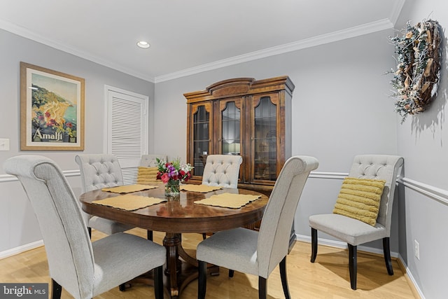 dining space featuring crown molding and light hardwood / wood-style flooring