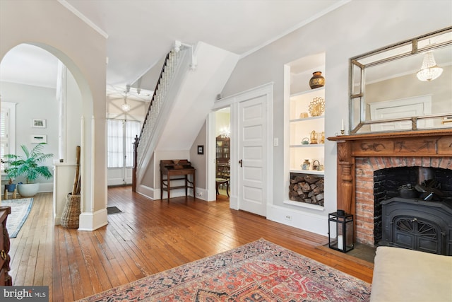 interior space featuring built in shelves, crown molding, and hardwood / wood-style flooring