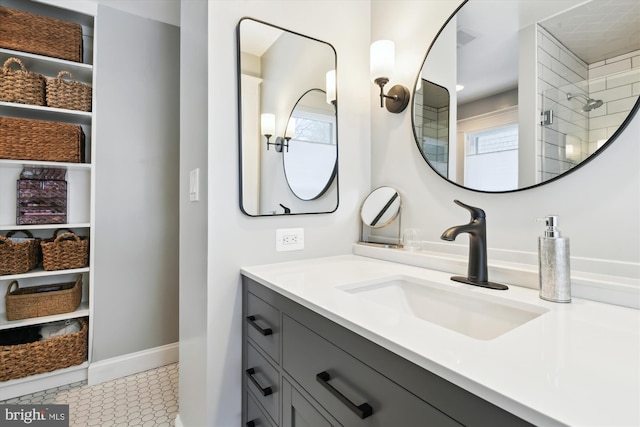 bathroom with walk in shower, vanity, and tile patterned flooring