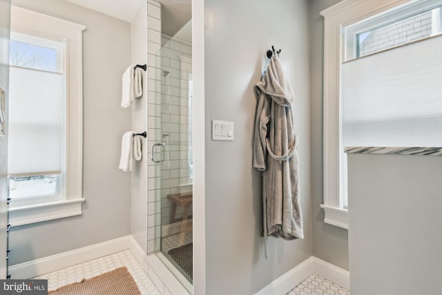 bathroom with a shower with shower door, a wealth of natural light, and tile patterned floors