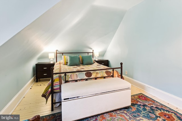 bedroom featuring vaulted ceiling and wood-type flooring