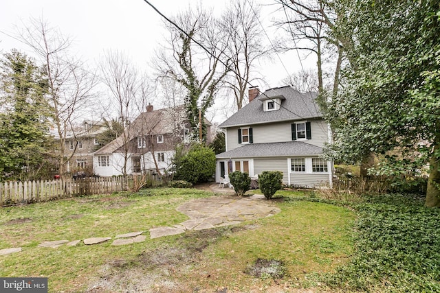 rear view of property featuring a lawn