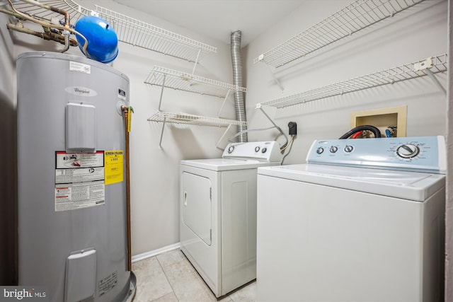 laundry room featuring light tile patterned floors, water heater, and washer and clothes dryer