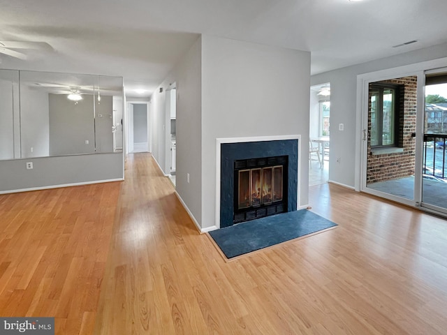 unfurnished living room with ceiling fan and light hardwood / wood-style floors