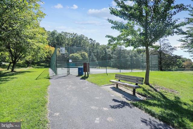 view of property's community featuring tennis court and a lawn