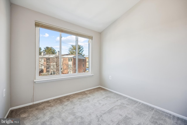 unfurnished room featuring light carpet and lofted ceiling