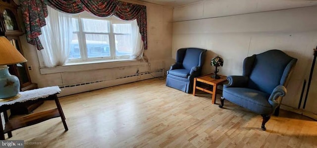 sitting room featuring a baseboard heating unit and light hardwood / wood-style flooring