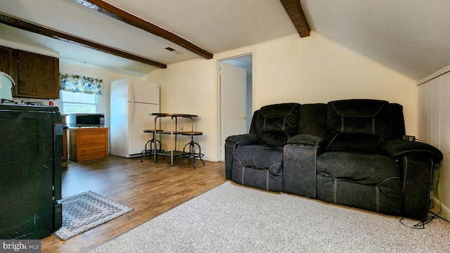 living room with lofted ceiling with beams and hardwood / wood-style floors