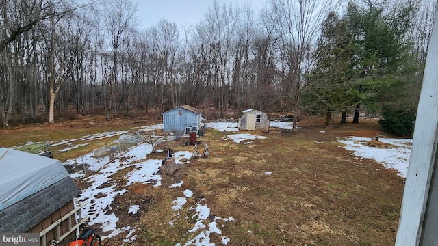 yard layered in snow with a shed