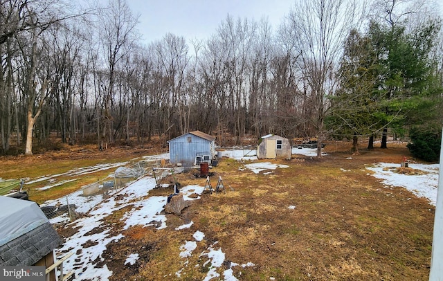 snowy yard featuring a storage shed