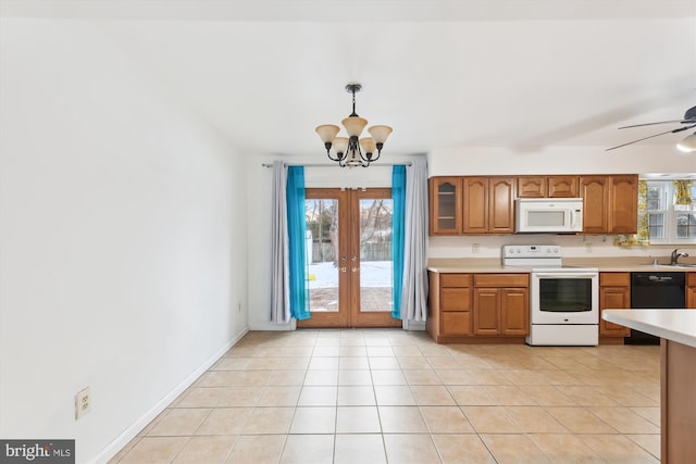 kitchen with ceiling fan with notable chandelier, pendant lighting, white appliances, french doors, and light tile patterned floors