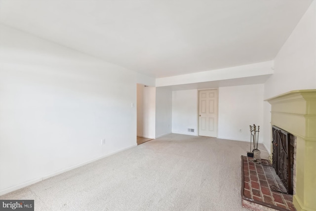 unfurnished living room with carpet and a brick fireplace