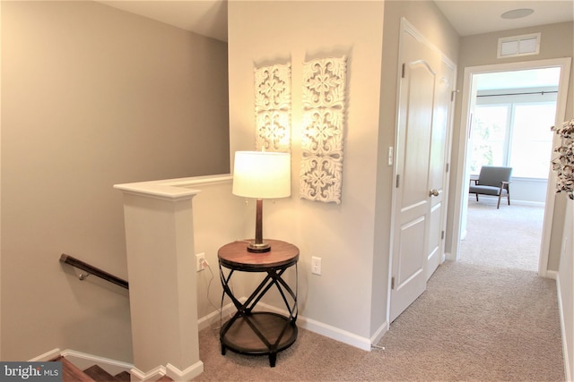 hall with light colored carpet