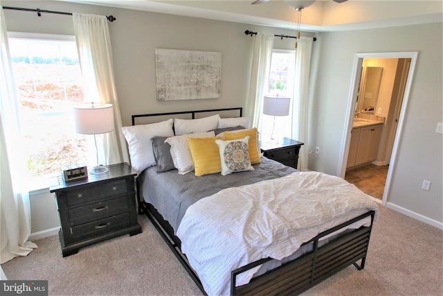 bedroom with light carpet and ensuite bathroom