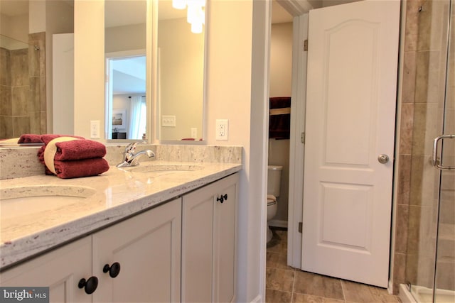 bathroom featuring toilet, walk in shower, and vanity