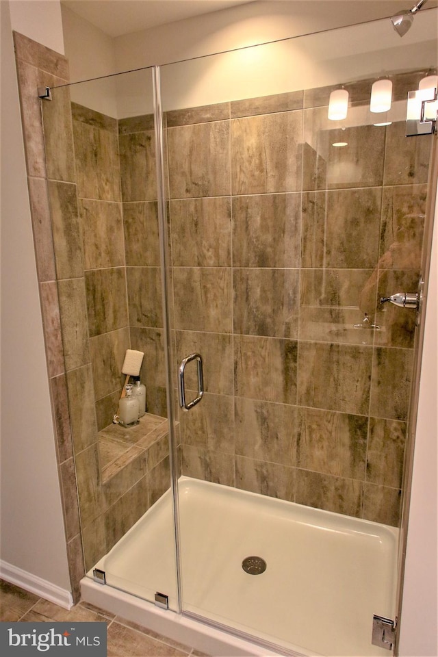 bathroom with tile patterned flooring and walk in shower