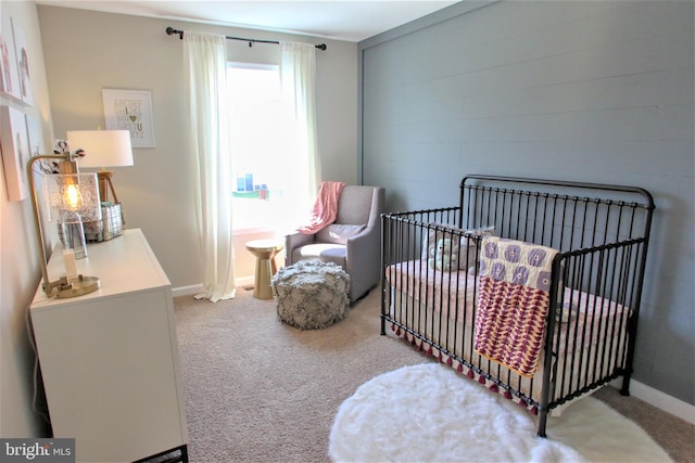 carpeted bedroom featuring a nursery area