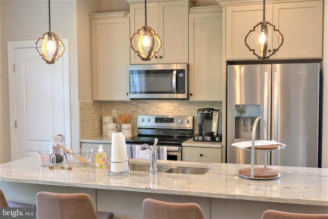 kitchen with a breakfast bar, stainless steel appliances, light stone counters, and tasteful backsplash