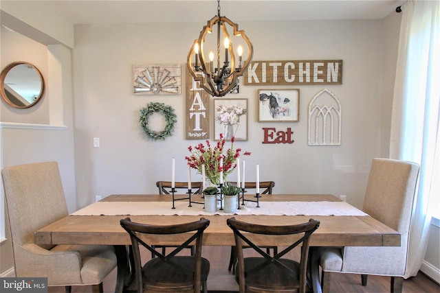 dining area with wood-type flooring and a notable chandelier