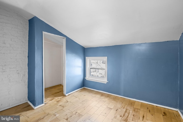 bonus room with light wood-type flooring and vaulted ceiling