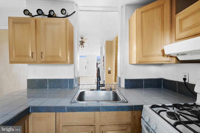 kitchen with white gas range, sink, tile countertops, and light brown cabinets