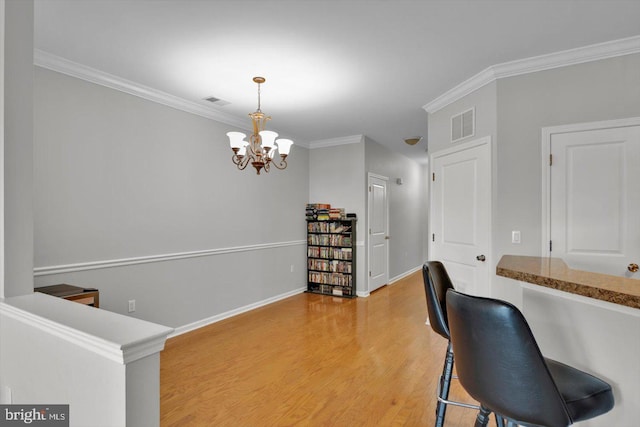 office space featuring ornamental molding, hardwood / wood-style flooring, and a notable chandelier