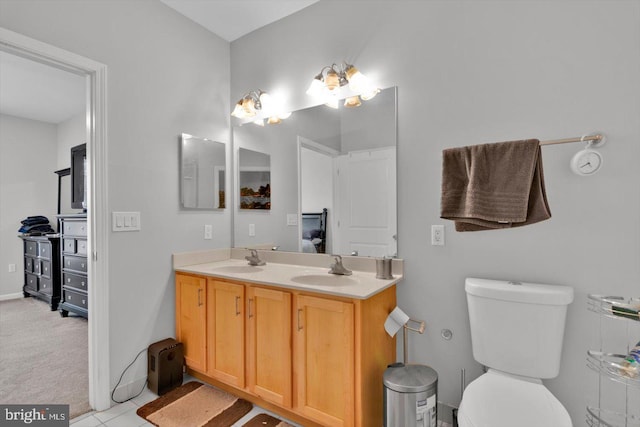 bathroom featuring toilet, vanity, and tile patterned flooring