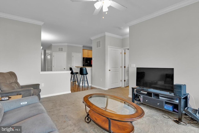 carpeted living room featuring ceiling fan and ornamental molding