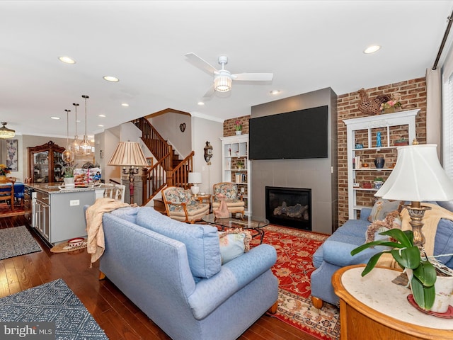 living room with ornamental molding, brick wall, dark hardwood / wood-style floors, and ceiling fan