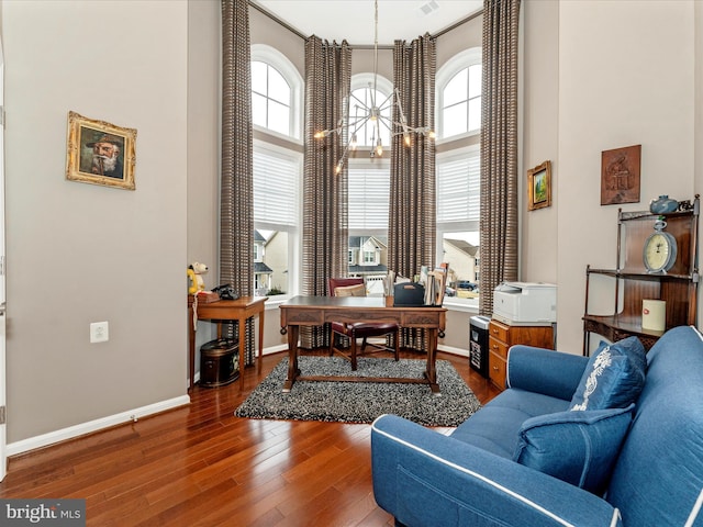 home office with wood-type flooring and a high ceiling