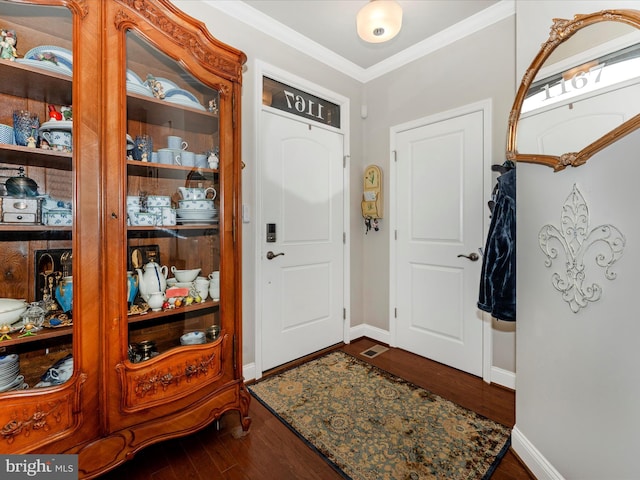 foyer entrance featuring ornamental molding and dark hardwood / wood-style floors