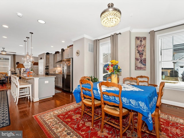 dining space featuring ornamental molding, dark hardwood / wood-style flooring, and a notable chandelier