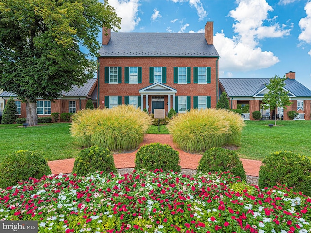 colonial inspired home with a front lawn