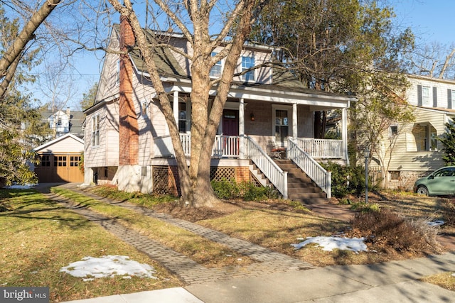 view of front of house featuring a garage, an outdoor structure, a front lawn, and a porch