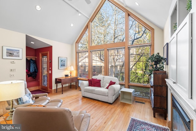 sunroom with lofted ceiling, plenty of natural light, and rail lighting