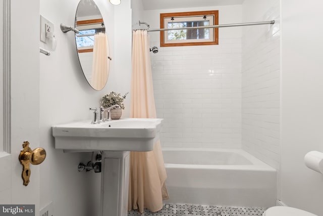 bathroom featuring shower / bath combination with curtain and toilet