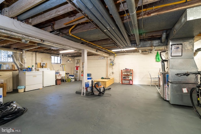 basement with sink, heating unit, and washer and clothes dryer