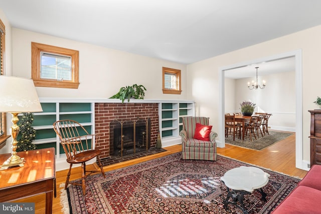 living room with hardwood / wood-style flooring, a fireplace, and a notable chandelier