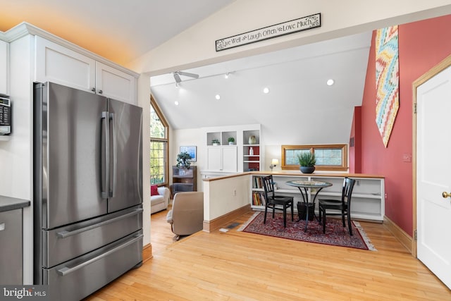 dining room featuring lofted ceiling, track lighting, and light hardwood / wood-style floors