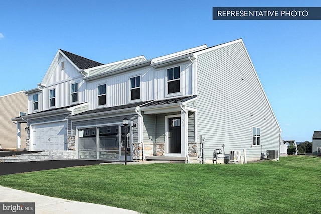 view of front of house featuring a garage, central AC, and a front yard