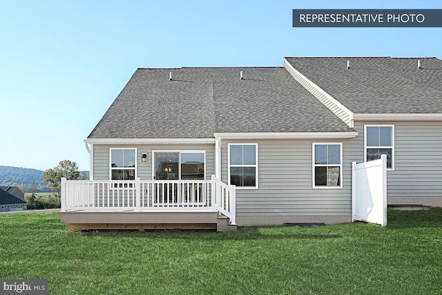 rear view of property with a wooden deck and a lawn