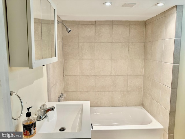 bathroom featuring sink and tile walls