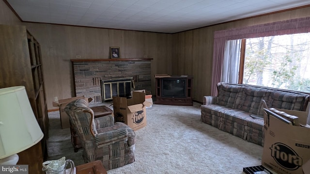 carpeted living room with wood walls and a stone fireplace