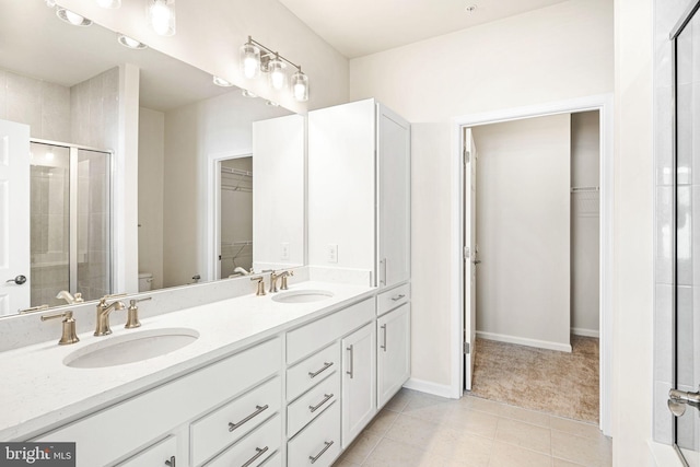 bathroom featuring vanity, a shower with shower door, tile patterned floors, and toilet