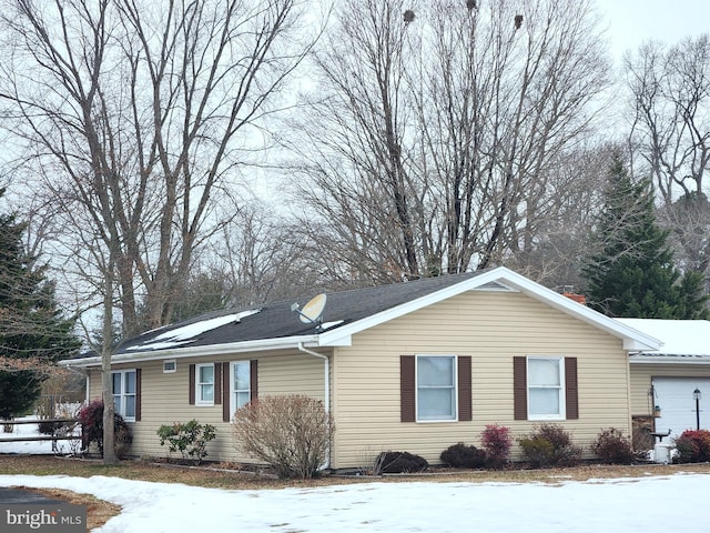 view of snowy exterior featuring a garage