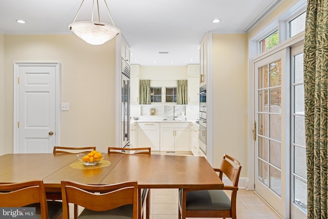 tiled dining room featuring sink and french doors