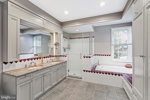 bathroom featuring tile patterned floors, vanity, and shower with separate bathtub